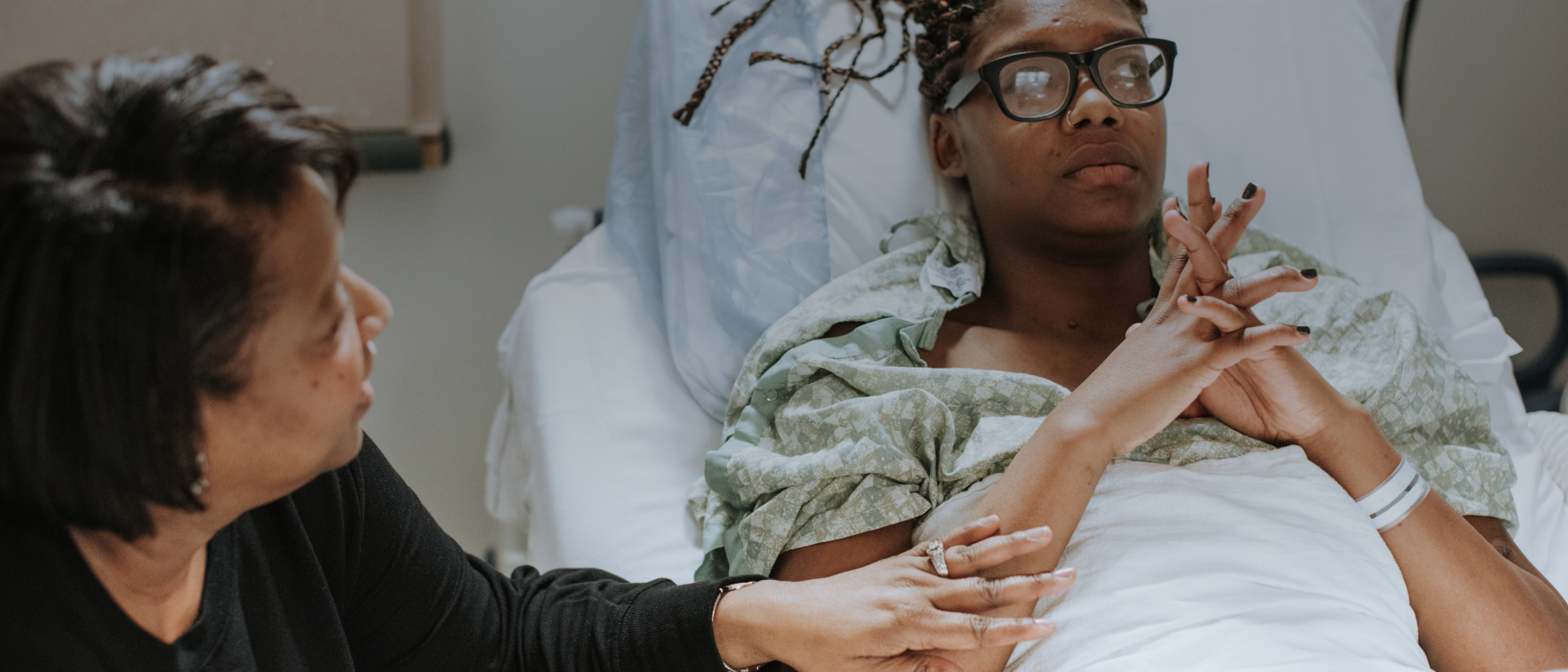 en patient i en sjukhussäng och en kvinna