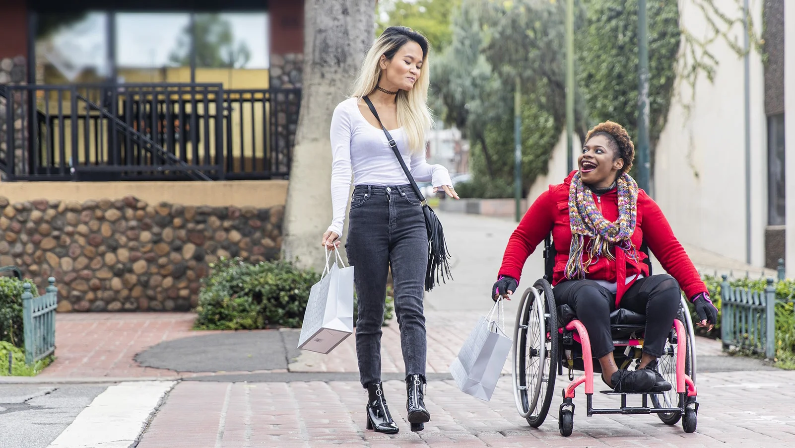 Une femme poussant un homme en fauteuil roulant