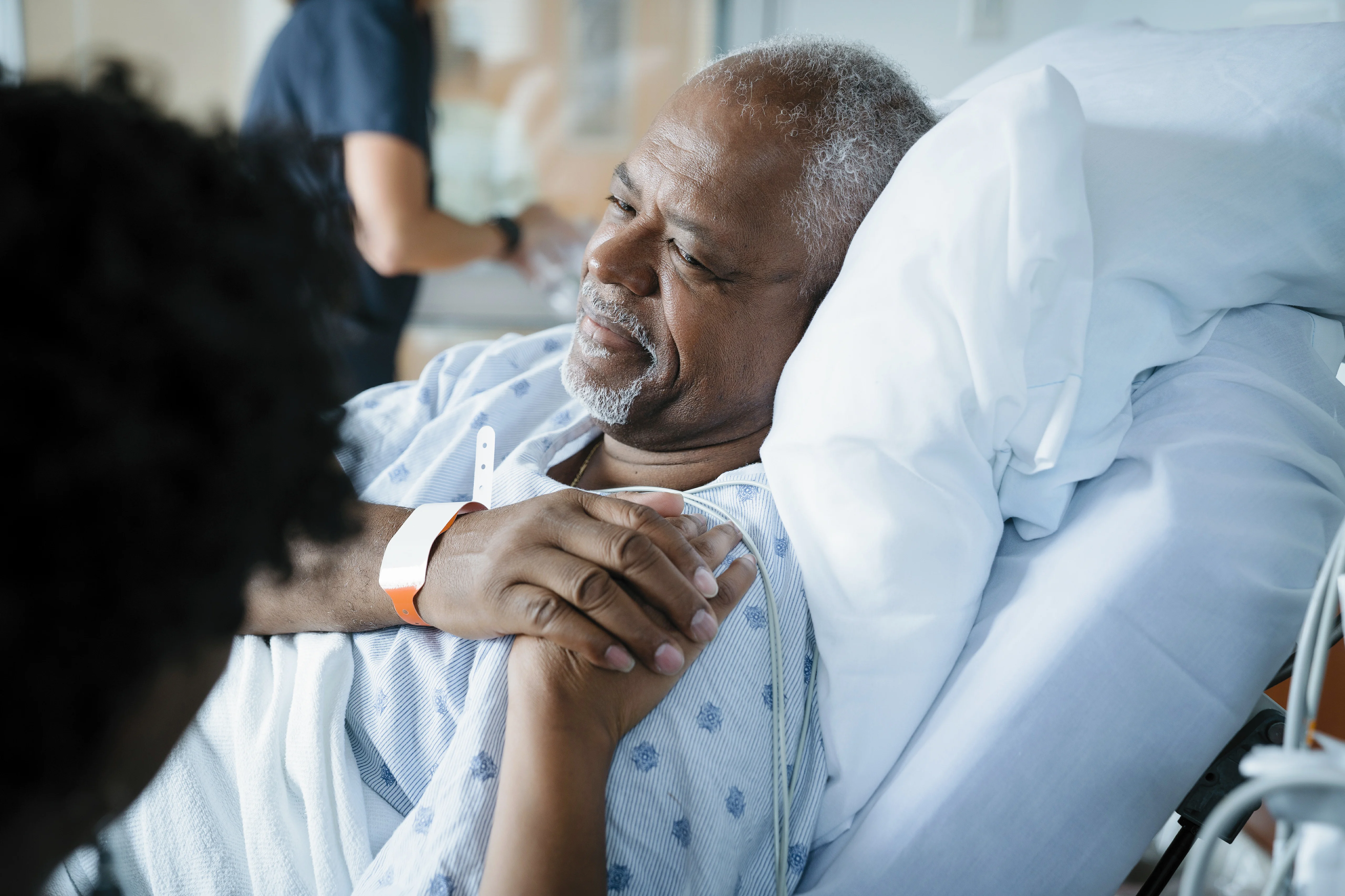 Nurse holding man's hand