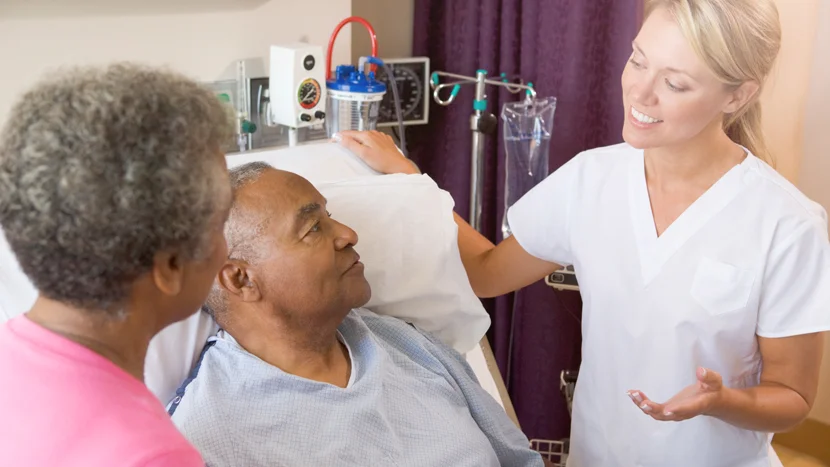 En läkare som talar med en patient och en kvinna
