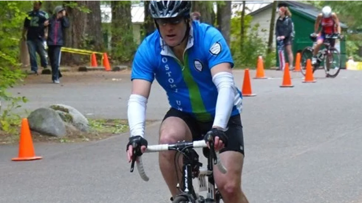 En mand med stomi, der nyder sin cykeltur under sin triatlon.